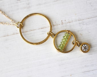 Long gold necklace with row of peridot and crystal drop