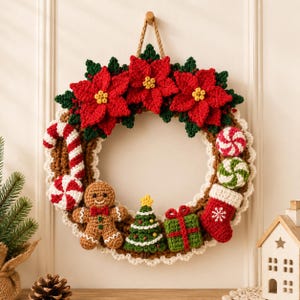 Puede incluir: Una corona navide&ntilde;a de ganchillo con tres grandes flores de pascua rojas con centros amarillos, un hombre de jengibre marr&oacute;n, un &aacute;rbol de Navidad verde, un regalo verde, un calcet&iacute;n rojo, bastones de caramelo y caramelos de menta.