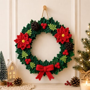 Puede incluir: Una corona de Navidad tejida a ganchillo con hojas de color verde oscuro, dos flores de pascua rojas con centros amarillos, pi&ntilde;as marrones, racimos de bayas rojas, ramitas verde claro y un lazo rojo prominente en la parte inferior, colgada de un cordel.