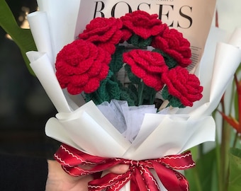 May include: A bouquet of crocheted red roses with green leaves, tied with a red ribbon and wrapped in white paper. The bouquet is labeled "A Fashionflower's Roses".