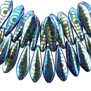 May include: A collection of iridescent blue and green glass beads with a black eye design. The beads are shaped like teardrops and have a glossy finish.