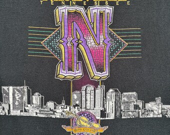 Camiseta vintage de cuello redondo con gráfico morado y negro de costura simple de Nashville, Tennessee, ciudad musical, hogar de la música country, de los años 90