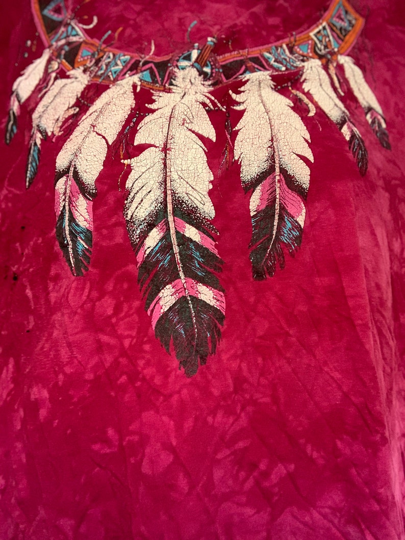 May include: A maroon tie-dye t-shirt with a Native American inspired design featuring a dreamcatcher with feathers.