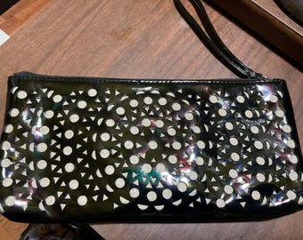 Laser cut faux patent leather clutch purse with wrist strap.