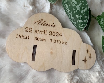 Puede incluir: Placa de madera con forma de nube con el nombre "Alessio" y detalles de nacimiento: 22 de abril de 2024, 16h21, 50cm y 3,070 kg. La placa tiene dos ranuras y recortes de estrellas.