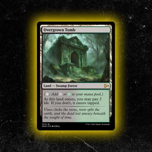 Op de afbeelding: Een groene en witte Overgrown Tomb kaart uit het Magic: The Gathering ruilkaartspel. De kaart toont een met mos begraven graf in een moerassig bos. Tekst bevat "Land - Swamp Forest" en spelinstructies.