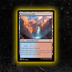 Può includere: Una carta di Magic: The Gathering intitolata "Thundering Falls". La carta presenta un'illustrazione paesaggistica di una cascata e montagne. Il testo recita "Land - Island Mountain" e include le istruzioni di gioco.