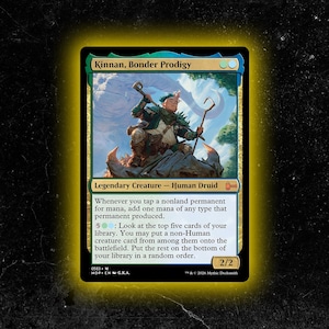 May include: A Magic: The Gathering card featuring "Kinnan, Bonder Prodigy." The card has a green, blue, and gold color scheme. The illustration depicts a humanoid figure with a staff. The card text includes "Legendary Creature - Human Druid."
