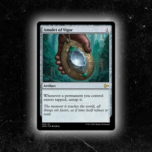 May include: A Magic: The Gathering card titled "Amulet of Vigor." The card features an illustration of a golden amulet with a large, clear gemstone. The card text describes the artifact's function. The background is a blurred forest scene.