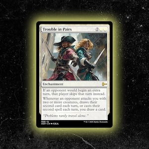 Op de afbeelding: Een Magic: The Gathering-kaart getiteld "Trouble in Pairs". De kaart toont een illustratie van twee figuren met zwaarden, gekleed in piratenkleding. De kaart is wit met zwarte tekst, inclusief het woord "Enchantment".