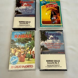 May include: Four vintage cassette tapes featuring Hawaiian music. The tapes include "Hawaii Calls" and "Aloha Hawaii" with colourful cover art depicting tropical scenes and performers. The cassettes are labelled with text.