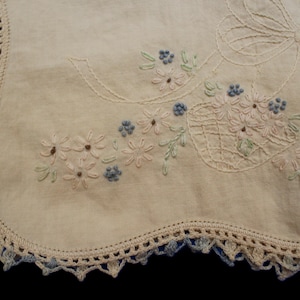 Chemin de table vintage brodé à la main avec des paniers de fleurs. Bordure colorée en dentelle fantaisie