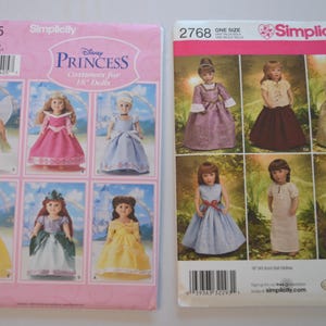 May include: Two Simplicity sewing pattern envelopes for 18-inch dolls. The left pink envelope, number 5705, features Disney Princess costumes. The right white envelope, number 2768, displays various doll dress designs with illustrations of finished outfits.