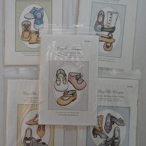 May include: Five clear plastic pouches containing Easy Sew Designs sewing patterns for various antique-style shoes and boots. Each package features a printed illustration of footwear designs with text indicating sizes ranging from 1 1/4 inches to 3 1/2 inches.