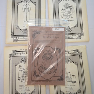 May include: Five Easy Sew Designs sewing patterns for dolls. The patterns feature black line drawings of clothing including a dress, slip, pantaloons, and underwear. Each paper envelope displays the brand name, pattern number, and size range in inches.