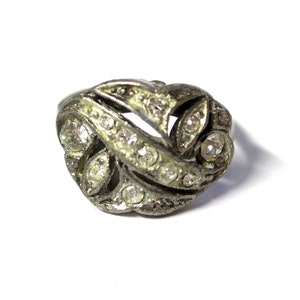 May include: A silver ring with a delicate design featuring a cluster of clear rhinestones set in a floral pattern.