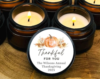 May include: Six lit amber glass candles with a wooden base. One candle has a lid with a pumpkin graphic and the text "Thankful for You". The text also includes "The Wilsons Annual Thanksgiving 2025".