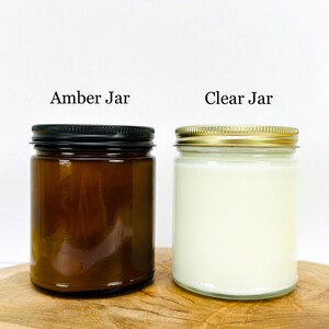 May include: Two candle jars, one amber and one clear, with gold lids. The text "Amber Jar" and "Clear Jar" is printed above each jar.