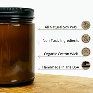 May include: A brown glass candle jar with a black lid. The candle is made with all natural soy wax, non-toxic ingredients, and an organic cotton wick. It is handmade in the USA.