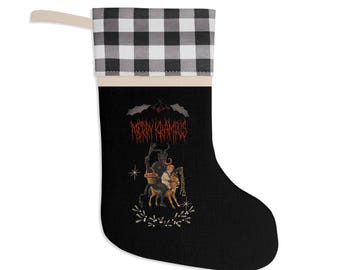 May include: Black Christmas stocking with a buffalo check cuff and a cream loop. The stocking features a Krampus graphic with the text "MERRY KRAMPUS" in red gothic lettering. A unique festive decoration.