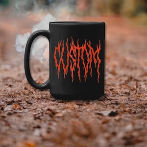 Könnte beinhalten: Schwarze Keramik-Kaffeetasse mit einem roten "CUSTOM"-Design in einer Metallschrift.
