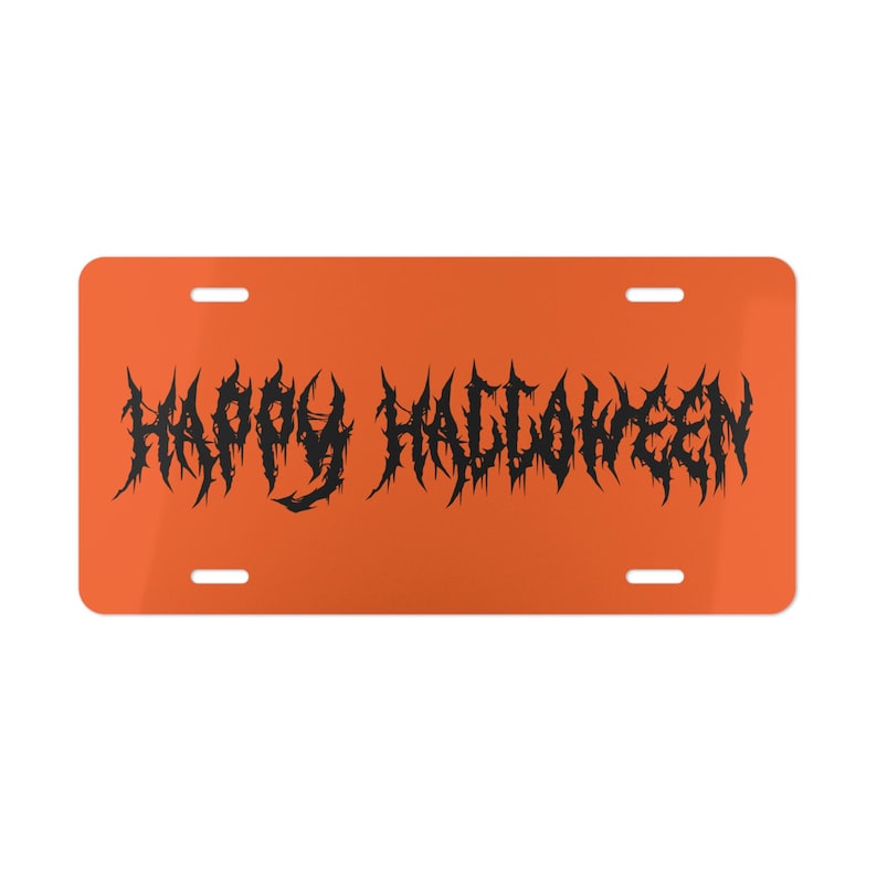 Może przedstawiać: Pomarańczowa tablica rejestracyjna z napisem "HAPPY HALLOWEEN" w kolczastej, gotyckiej czcionce. Tablica posiada cztery otwory montażowe i błyszczące wykończenie. Świąteczna dekoracja na Halloween.