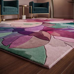 Peut inclure: Un grand tapis pr&eacute;sentant un motif floral abstrait et audacieux avec des sections sculpt&eacute;es en couches dans des tons de violet profond, magenta, rose tendre et vert sauge. Le tapis poss&egrave;de une surface touffet&eacute;e aux contours courbes.
