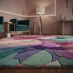 Peut inclure: Un grand tapis pr&eacute;sentant un motif floral abstrait multicolore avec des nuances de violet profond, magenta, bleu sarcelle, vert sauge et rose tendre. Le tapis poss&egrave;de une surface &agrave; poils coup&eacute;s textur&eacute;e avec des formes organiques distinctes.