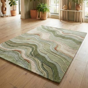 May include: A rectangular area rug with a flowing, abstract design. The rug features a pattern of wavy lines in shades of green, beige, and rust. The rug is placed on a hardwood floor, and the overall aesthetic is natural and organic.