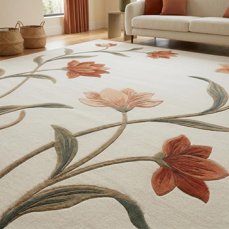 May include: A large area rug with an off-white background featuring a floral pattern. The design includes large, stylized flowers in shades of terracotta and soft peach, connected by long, flowing stems and leaves in muted sage green and brown tones.