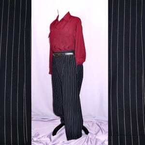 May include: Black and white striped pants with a wide leg and a red button-down shirt. The pants have a belt loop and a belt.
