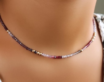 Puede incluir: Un delicado collar con pequeñas cuentas facetadas en tonos morado, rosa y dorado. Las cuentas están ensartadas para crear una joya sutil y elegante. El collar está diseñado para ser usado cerca del cuello.