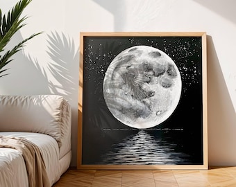 Puede incluir: Una obra de arte enmarcada representa una luna llena sobre el agua. La luna está representada en tonos grises y blancos sobre un fondo negro con estrellas. El agua refleja la luz de la luna. El marco es de madera clara.