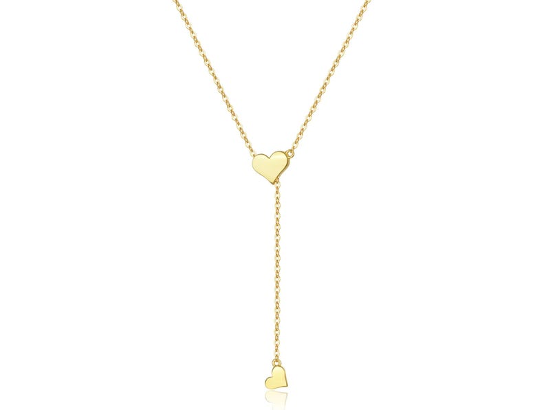 May include: A gold chain necklace with two heart-shaped pendants. The necklace is delicate and feminine.