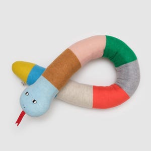 Könnte beinhalten: Ein farbenfrohes gestricktes Schlangenspielzeug mit einem blauen Gesicht und gelben, blauen, braunen, rosa, grünen, grauen und roten Streifen.