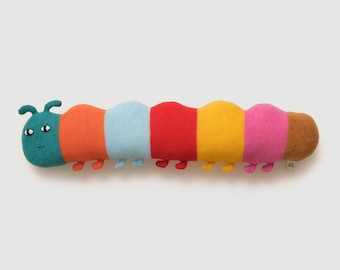 May include: A colorful knitted caterpillar pillow with a teal head and black eyes. The pillow is striped with orange, light blue, red, yellow, pink, and brown.