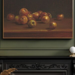 May include: A still life painting of a bowl of apples on a wooden table. The apples are various shades of red and green, and some are slightly bruised. The painting is framed in a gold frame.