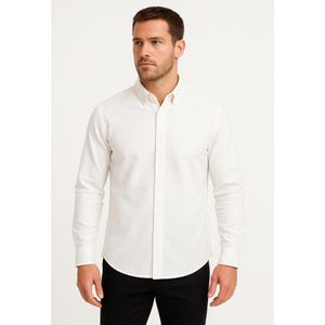 May include: A long-sleeved, button-down shirt in a cream color. The shirt has a classic collar and is buttoned up the front. The model is wearing black pants. The shirt is made of a textured fabric.