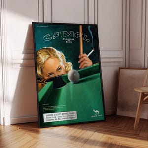 May include: A framed vintage Camel cigarettes advertisement. The poster shows a woman with blue eyes, a pool table, and a lit cigarette. The text reads "CAMEL PLEASURE BURN" and "SURGEON GENERAL'S WARNING". The Camel logo is visible.