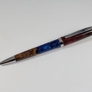 May include: A silver and wood pen with a blue and brown wood grain pattern.