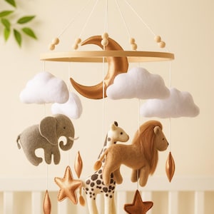 以下が含まれることがあります： 象、キリン、ライオンなどのフェルト製の動物のフィギュア、白い雲、銅色の星、三日月が特徴のベビーモバイル。木製のリングと木製のビーズから吊り下げられています。