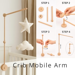May include: A wooden crib mobile arm with a star and cloud hanging from it. The mobile arm is attached to a white cot. The image also shows the assembly steps of the mobile arm.