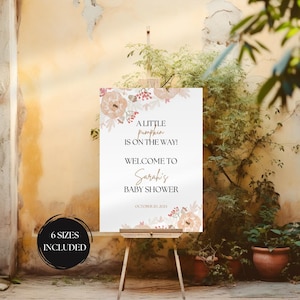 Puede incluir: Un cartel blanco imprimible con un diseño floral en tonos melocotón y rosa. El texto dice "A little pumpkin is on the way! Welcome to Sarah's Baby Shower October 20, 2024".