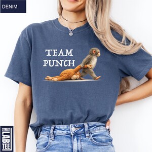 May include: Denim blue t-shirt with the text "TEAM PUNCH" and a graphic of two monkeys. One monkey is standing and pulling the other monkey. The shirt has a Street Lab Tee label.