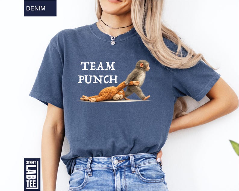 May include: Denim blue t-shirt with the text "TEAM PUNCH" and a graphic of two monkeys. One monkey is standing and pulling the other monkey. The shirt has a Street Lab Tee label.