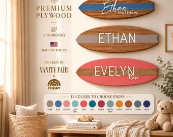 May include: Three surfboard-shaped wooden wall signs featuring personalized names. The top sign is brown wood with a blue stripe and the name Ethan Matthew. The middle sign is brown wood with a gray stripe and the name ETHAN. The bottom sign is coral with a brown stripe and the name EVELYN Rose. A color palette chart displays 12 options.