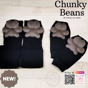 May include: Black fingerless gloves with a gray paw print design. The gloves are made of a knitted material and feature the text "Chunky Beans" and "NEW!" in the image.