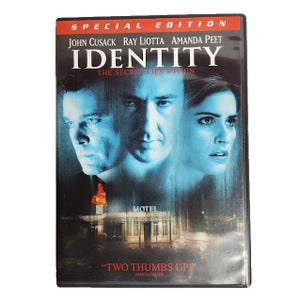 May include: Special Edition DVD of the movie "Identity" featuring John Cusack, Ray Liotta, and Amanda Peet. The cover has a blue-toned image of the actors' faces and a motel. The text "Two Thumbs Up" is also visible.