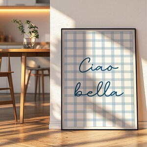 Puede incluir: Una impresi&oacute;n enmarcada con un patr&oacute;n de cuadros azules y blancos y el texto "Ciao bella" en escritura cursiva azul.