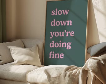 May include: A teal green framed poster with the text "slow down you're doing fine" in pink lettering.